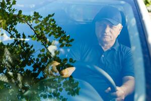 Elderly man driving a car photo