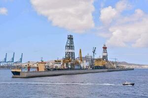 a boat is traveling through the water near an oil rig photo