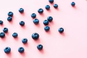 Colorful fruit pattern of blueberries on pink background. Top view. Flat lay photo