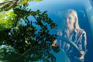 confidente y hermosa. atractivo joven mujer en casual vestir conducción un coche foto