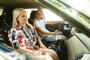 contento joven hombre y mujer en un coche disfrutando un la carretera viaje en un verano día. foto