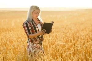 Christian woman praying on holy bible and wooden cross in barley field on summer. Woman pray for god blessing to wishing have a better life and believe in goodness. photo