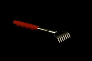 a back scratcher with a red handle photo