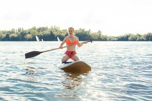 Action Shot of Young Woman on Paddle Board photo