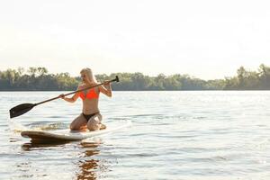 Action Shot of Young Woman on Paddle Board photo