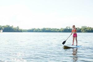 A beautiful woman practicing paddle on a beautiful sunny day photo