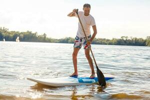 silueta de estar arriba paleta huésped remar a puesta de sol foto