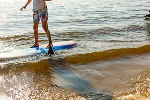 Silhouette of stand up paddle boarder paddling at sunset photo