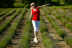 mujer en pie con abierto brazos en un lavanda campo foto