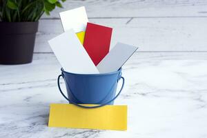 Colorful paper inside of a blue bucket with copy space. photo