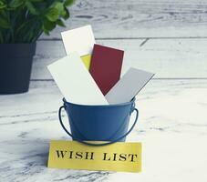 Colorful paper inside of a blue bucket with Wish list label. photo