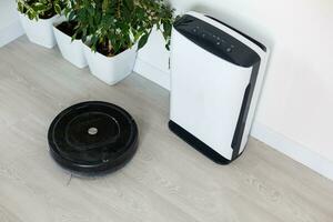 robot vacío limpiador y aire purificador trabajando en moderno hogar foto