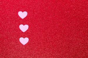 pink hearts on a red background for a greeting card or banner for Valentine's Day, copy space photo
