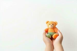 AI generated Child hands holding smiling cute little teddy bear on white background with copy space. photo