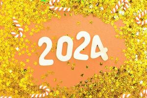 wooden number 2024 on christmas shiny Peach Fuzz background with sparkle festive golden confetti photo