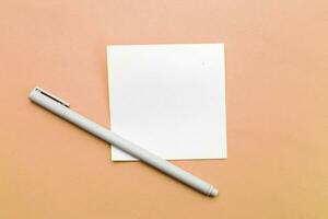 Top view of blank note paper with pen on Peach Fuzz background photo