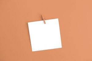 sticker with empty mockup for your text hanging on the pin on Peach Fuzz background. photo