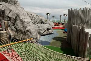 A relaxation area on a cruise ship deck with artificial rock features, water elements, and a hammock, inviting passengers to unwind and enjoy the ocean views photo