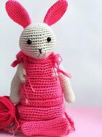 AI generated Knitted rabbit in pink dress. st. valentine's day decor. knitted toy, amigurumi. valentines day greeting card ai generated photo