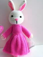 AI generated Knitted rabbit in pink dress. st. valentine's day decor. knitted toy, amigurumi. valentines day greeting card ai generated photo