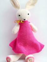 AI generated Knitted rabbit in pink dress. st. valentine's day decor. knitted toy, amigurumi. valentines day greeting card ai generated photo