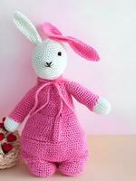 AI generated Knitted rabbit in pink dress. st. valentine's day decor. knitted toy, amigurumi. valentines day greeting card ai generated photo