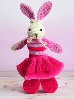 AI generated Knitted rabbit in pink dress. st. valentine's day decor. knitted toy, amigurumi. valentines day greeting card ai generated photo