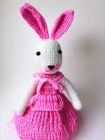 AI generated Knitted rabbit in pink dress. st. valentine's day decor. knitted toy, amigurumi. valentines day greeting card ai generated photo