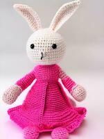 AI generated Knitted rabbit in pink dress. st. valentine's day decor. knitted toy, amigurumi. valentines day greeting card ai generated photo