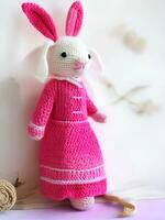 AI generated Knitted rabbit in pink dress. st. valentine's day decor. knitted toy, amigurumi. valentines day greeting card ai generated photo