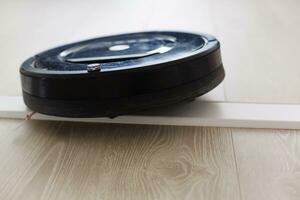 The automated robot vacuum cleaner of a roundish form, can make cleaning in hard-to-reach spots. photo