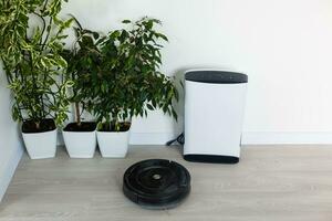 Robot vacuum cleaner and air purifier working in modern home photo