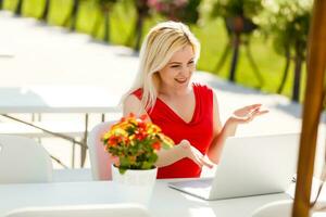 Happy woman planning vacations on line searching information in a laptop in a resort or hotel in the beach photo