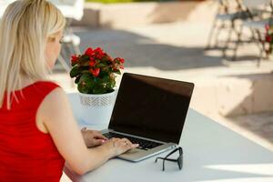 Happy woman planning vacations on line searching information in a laptop in a resort or hotel in the beach photo