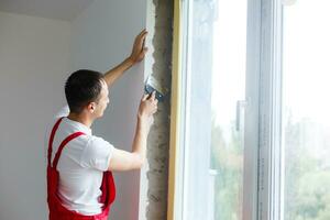 Repair in the slopes of the window. The process of applying a layer of plaster on the sides of the window. photo