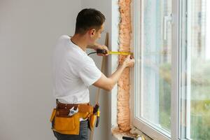 Young handyman repair window with screwdriver photo