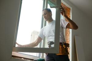 male industrial builder worker at window installation in building construction site photo