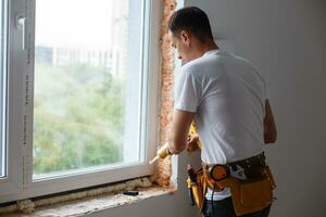 Caulking a new window frame photo