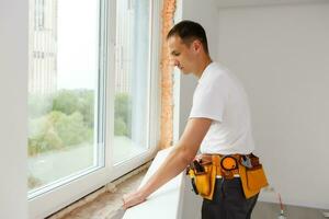 Young handyman repair window with screwdriver photo