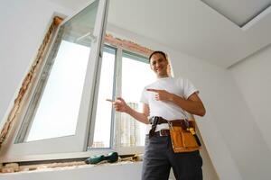 Young handyman repair window with screwdriver photo