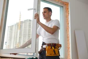 Young handyman repair window with screwdriver photo
