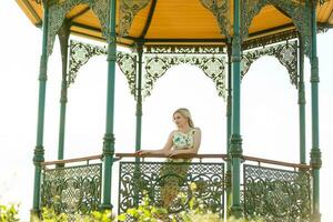 Pretty, atractive woman standing in a gazebo in a park photo