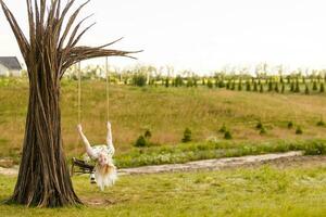 A young woman is swinging on a swing in a park setting. photo