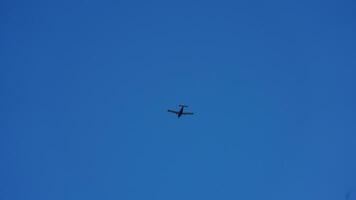 An airplane flying through the clear blue sky in the sunny day photo