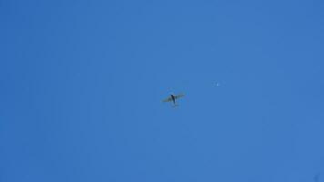 An airplane flying through the clear blue sky in the sunny day photo