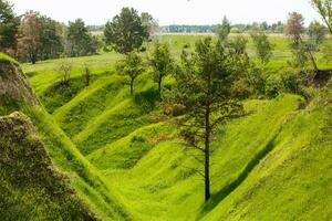 Spring photography, meadows, fields, ravines, hills, rural landscape. A deep, narrow gorge with steep slopes. A naturally raised area of land, not as high or craggy as a mountain. photo