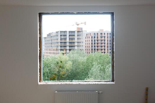 Empty frame on a wide panoramic window. Gorgeous view from the window of an apartment in a multi-storey building. Roofs of houses and trees from a height. Beautiful view through the window. Frame for photo