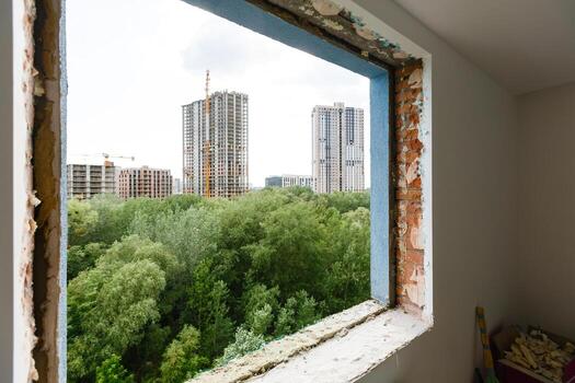 Empty frame on a wide panoramic window. Gorgeous view from the window of an apartment in a multi-storey building. Roofs of houses and trees from a height. Beautiful view through the window. Frame for photo