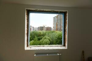 vacío marco en un amplio panorámico ventana. maravilloso ver desde el ventana de un Departamento en un de muchos pisos edificio. techos de casas y arboles desde un altura. hermosa ver mediante el ventana. marco para foto