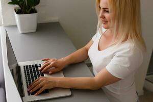 Close-up Of Young Woman Using Laptop online at home photo
